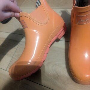 Coral bright orange rain boots. They are darker in person than in the photo